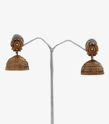Pair of gold jhumka earrings  With Flower Design on a dark background