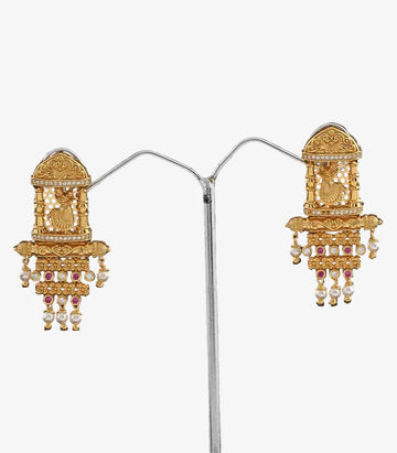 Pair Of Gold Earrings With Intricate Temple and Dancing Girl Designs on a dark background