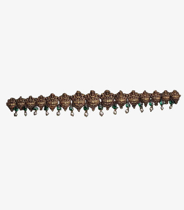 This is a traditional antique-finish Temple Jewelry Vaddanam (waist belt) featuring intricate goddess motifs, green stones, and pearl droplets.